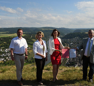 Klimaschutzministerin Anne Spiegel überreicht an der Mosel den Förderbescheid.