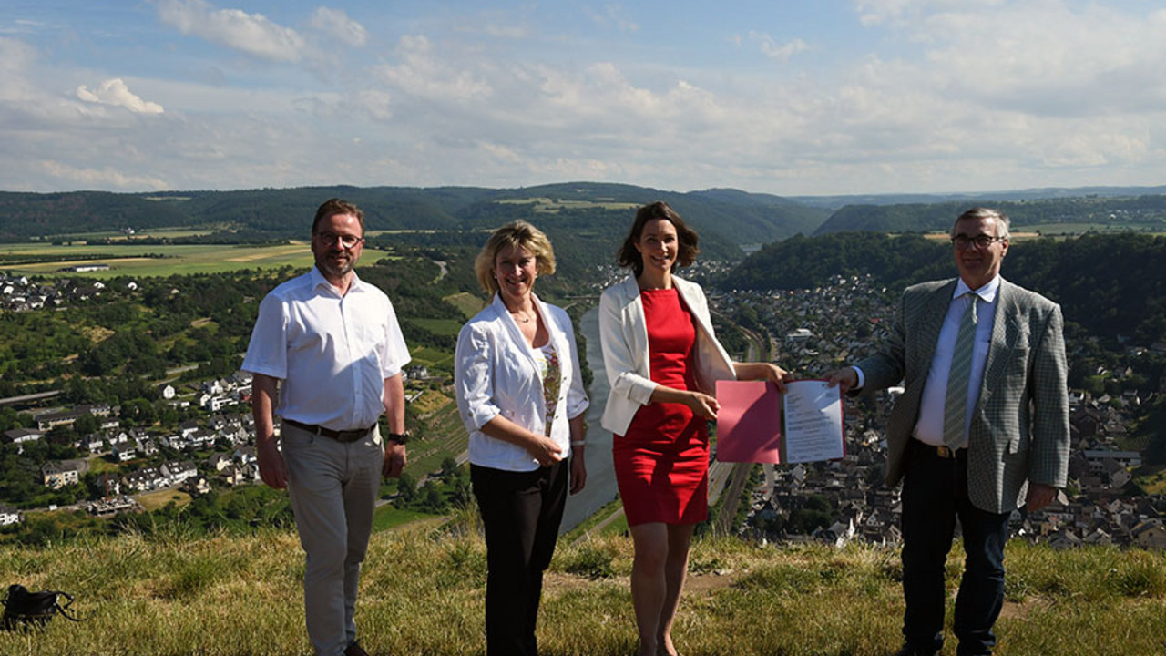 Klimaschutzministerin Anne Spiegel überreicht an der Mosel den Förderbescheid.