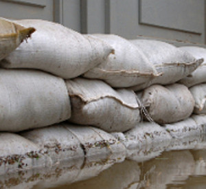 Sandsäcke, die zum Schutz vor Hochwasser vor einer Haustür aufgebaut sind. Foto: Fotolia