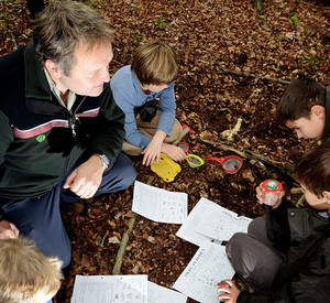 Schülergruppe mit Förster im Wald