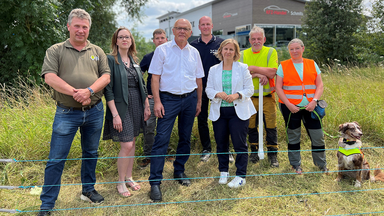 Gruppenbild mit Umweltministerin Katrin Eder am mobilen Elektrozaun