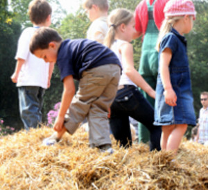 Kinder spielen auf einem Heuhaufen, Foto Landwirtschaftskammer RLP