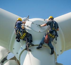 Monteure arbeiten am Rotor einer Windkraftanlage