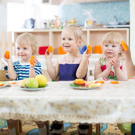 Kleinkinder am Tisch mit Obsttellern