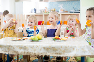 Kleinkinder am Tisch mit Obsttellern