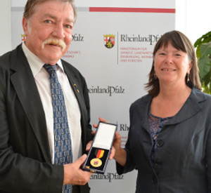 Umweltministerin Ulrike Höfken überreicht Georg Ohs die Verdienstmedaille.