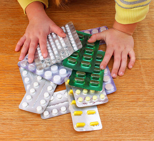 Kinderhände greifen nach Medikamenten
