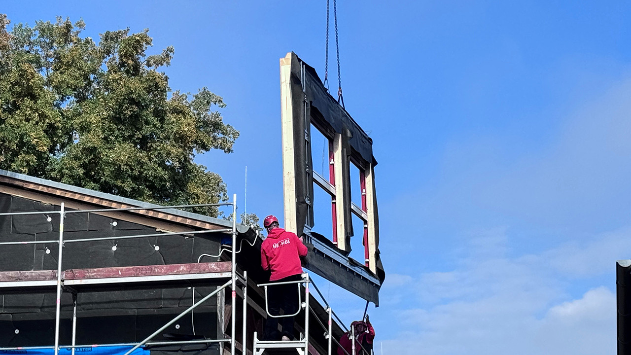 Montage eines vorgefertigten Fassadenelements an der Schulturnhalle in Körperich