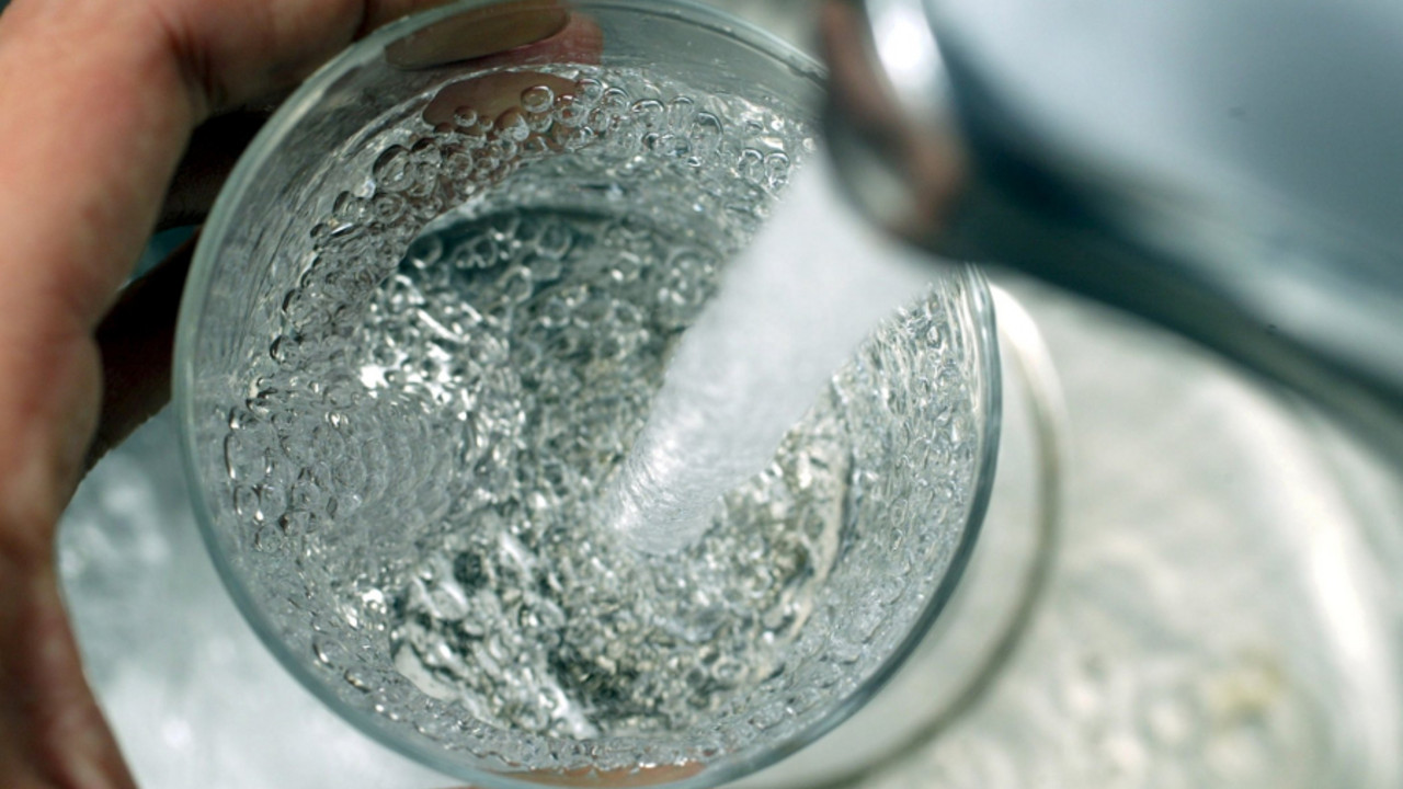 Wasser aus einem Hahn fließt in ein Glas