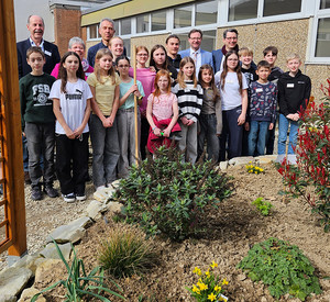 Klimaschutzstaatssekretär Michael Hauer mit Schülerinnen und Schülern auf dem umgestalteten Schulhof der Friedrich-Spee-Realschule plus in Neumagen-Dhron