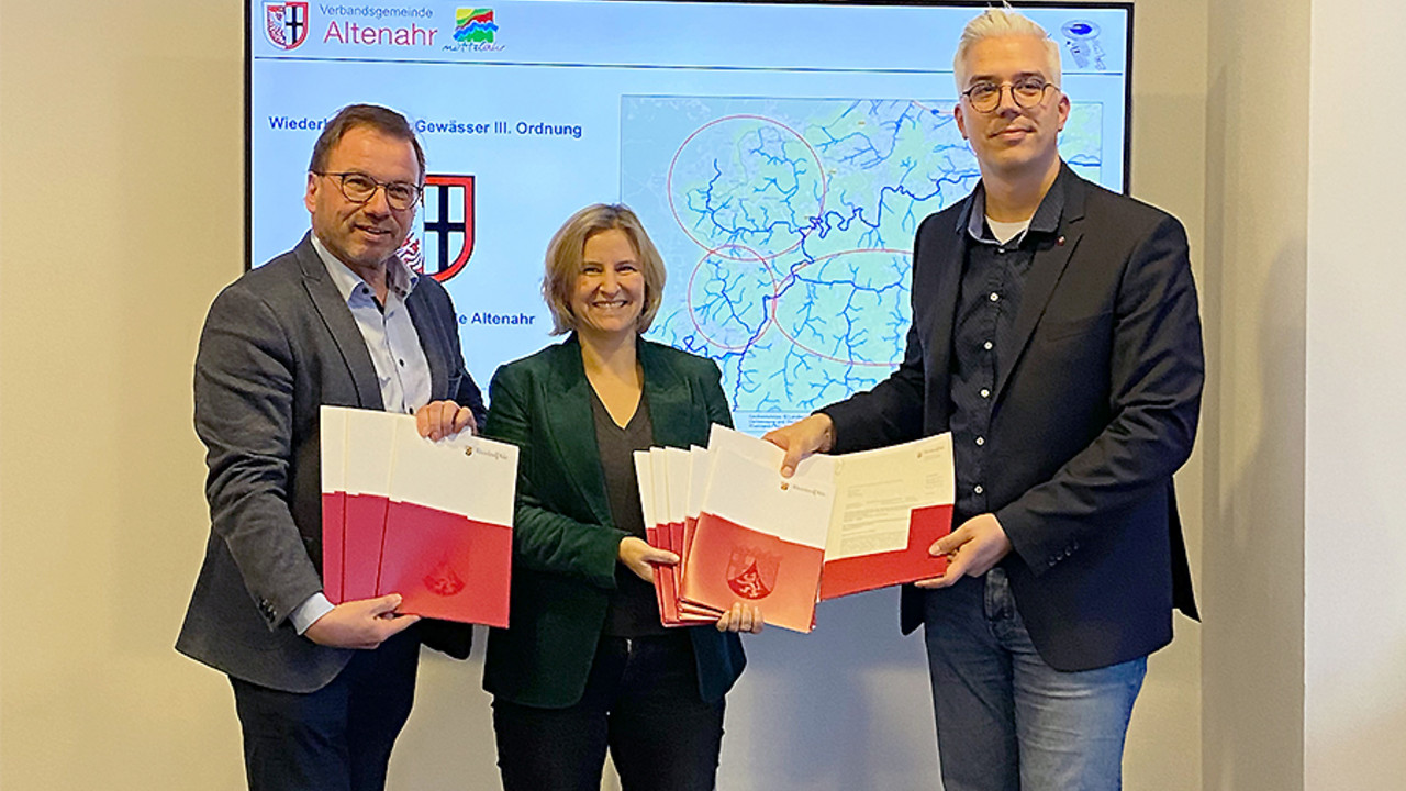 Im Beisein von SGD-Nord Präsident Wolfgang Treis übergibt Klimaschutzministerin Katrin Eder VG-Bürgermeister Dominik Gieler die Förderbescheide.