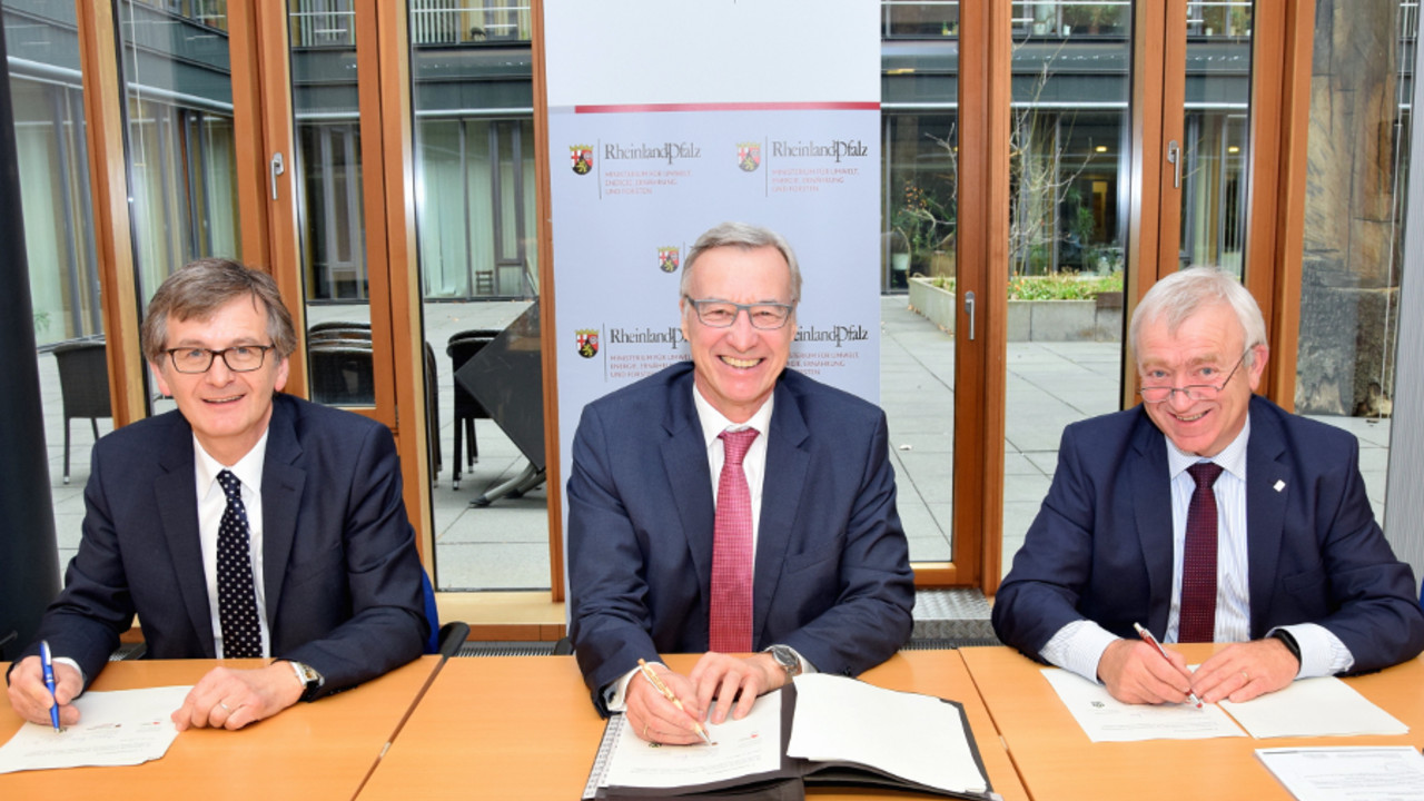 Forststaatssekretär Dr. Thomas Griese (Mitte), Hans-Günter Fischer, Vorsitzender des Waldbesitzerverbandes Rheinland-Pfalz (links) und Aloysius Söhngen, stellvertretender Vorsitzender des Gemeinde- und Städtebundes Rheinland-Pfalz (rechts), unterzeichnen das Gesamtkonzept.