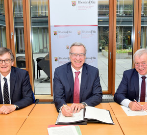 Forststaatssekretär Dr. Thomas Griese (Mitte), Hans-Günter Fischer, Vorsitzender des Waldbesitzerverbandes Rheinland-Pfalz (links) und Aloysius Söhngen, stellvertretender Vorsitzender des Gemeinde- und Städtebundes Rheinland-Pfalz (rechts), unterzeichnen das Gesamtkonzept.