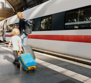 Familie mit Gepäck auf Bahnsteig