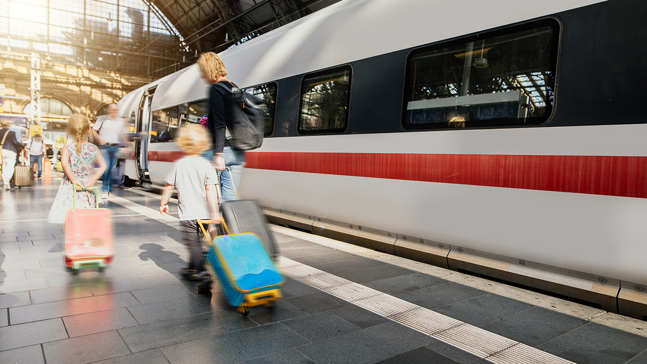 Familie mit Gepäck auf Bahnsteig