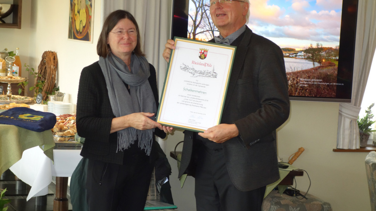 Umweltminiserterin Ulrike Höfken überreicht Ortsbürgmeister Peter Hartogh die Auszeichung